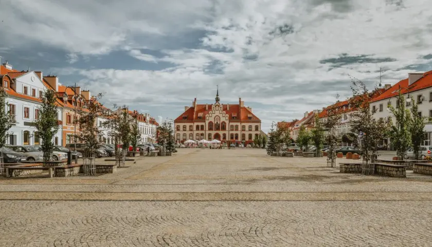 Ratusz i kolorowe kamienice na brukowanym rynku. Wspaniałe atrakcje turystyczne miasta, idealne na spacer.