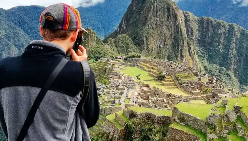 Niesamowita wycieczka do Peru! Turysta z aparatem podziwia Machu Picchu, majestatyczne ruiny Inków w otoczeniu gór.