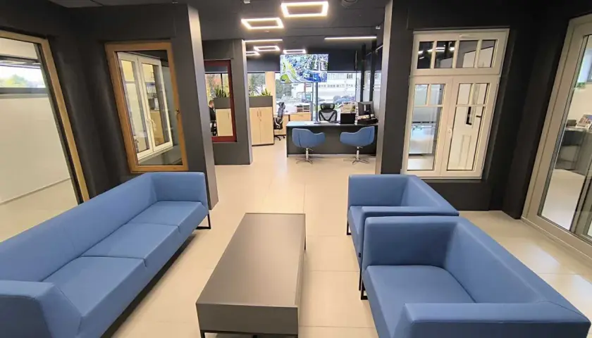 Nowoczesne wnętrze salonu okien i drzwi z niebieskimi sofami i stolikiem.