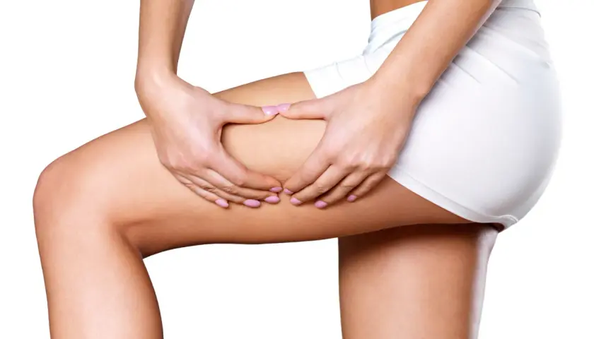 Mani che stringono la coscia, simulando un massaggio interno coscia per migliorare la circolazione e la tonicità.