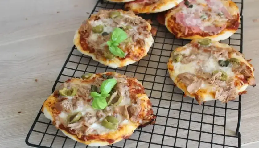 Mini pizze z tuńczykiem, oliwkami i bazylią na ruszcie. Idealne na szybką przekąskę.