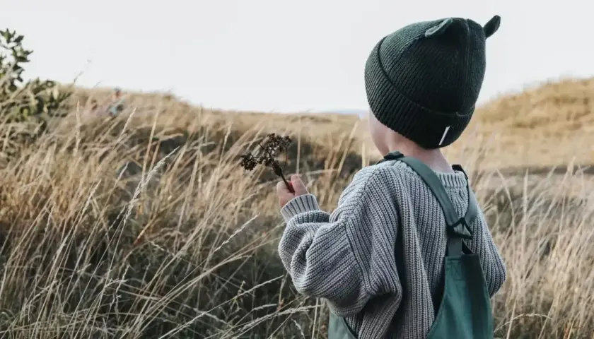 Jesienią w góry dziecko ubierz ciepło: czapka z uszkami, sweter i ogrodniczki.