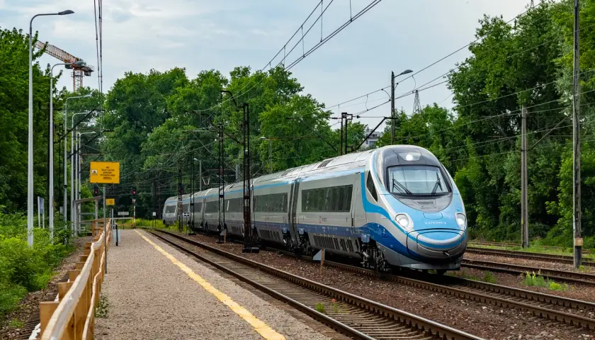Srebrno-niebieski pociąg Pendolino mija peron. Ile pociągów Pendolino jest w Polsce? Ten jeden jest na torach.