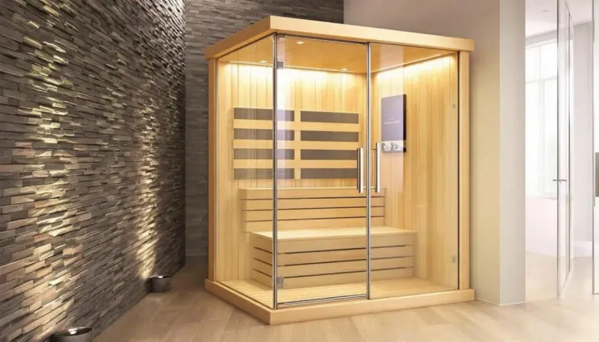 Une cabine de sauna moderne en bois et verre, idéale pour se détendre. Combien de sauna par semaine pour un bien-être optimal ?