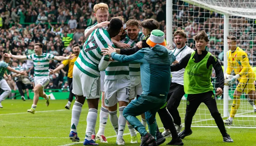 Piłkarze z Glasgow świętują zwycięstwo, otoczeni przez kibiców i młodych pomocników.