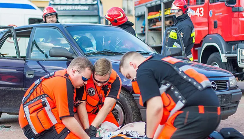 Ratownicy medyczni ćwiczą udzielanie pomocy poszkodowanemu po wypadku samochodowym. To jak wygląda egzamin KPP w praktyce.