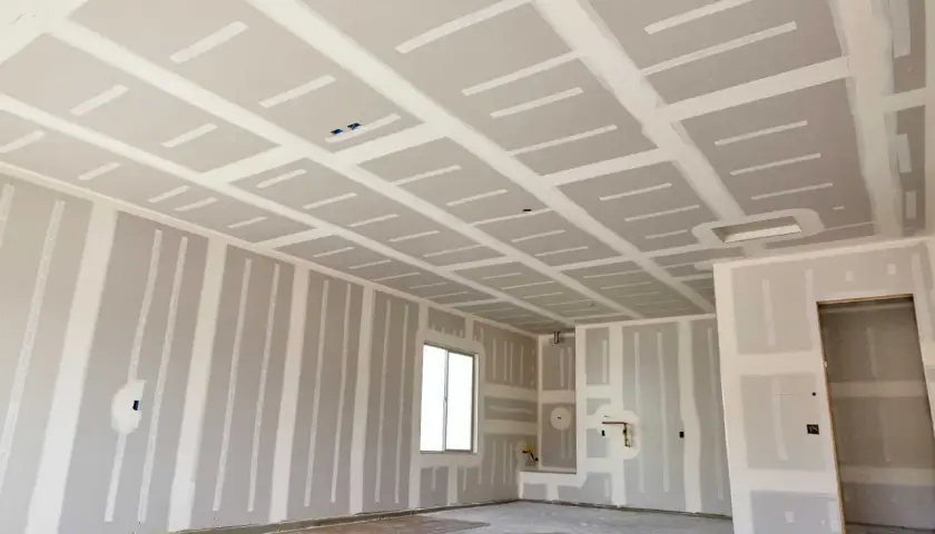 Interno di un locale in costruzione con pareti e soffitto in cartongesso, in attesa del passaggio degli impianti.