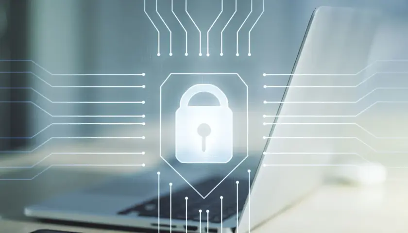 Cyfrowy zamek symbolizuje bezpieczeństwo danych i kryptologię. Laptop i schemat obwodów podkreślają technologiczną naturę ochrony.