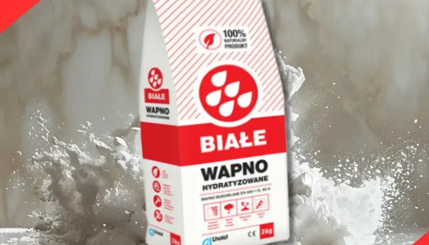 Białe wapno budowlane w worku, otoczone chmurą pyłu. Idealne do prac remontowych.