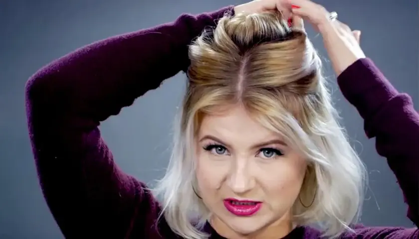 Mujer con pelo rubio corto haciendo un semirecogido con las manos.