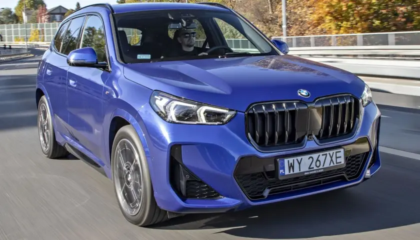 Niebieskie BMW X1 w ruchu drogowym. Sprawdź aktualną bmw x1 cena i ofertę.