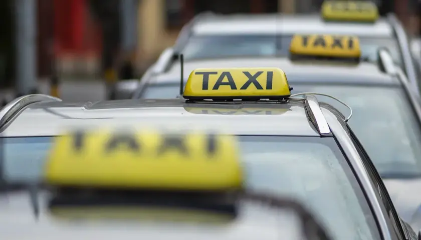 Rząd żółtych taksówek z napisem "TAXI" na dachach.