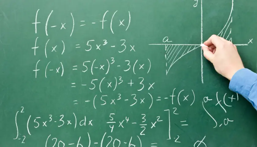 Rysunek na tablicy pokazuje obliczenia matematyczne, w tym całki i funkcje, ilustrujące, co to system zero jedynkowy a binarny.