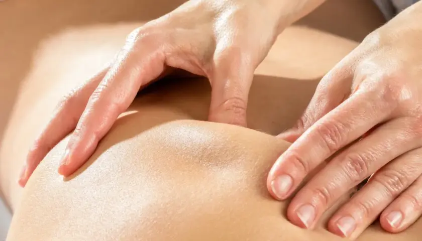Mains expertes prodiguant un massage kinésithérapique apaisant, soulageant les tensions musculaires.