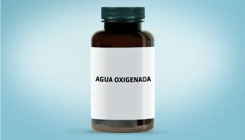 Botella de agua oxigenada para los dientes, con etiqueta blanca y tapa negra, sobre fondo azul claro.