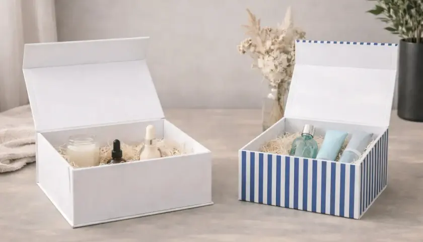 Zwei offene Geschenkboxen, eine weiße mit Pflegeprodukten, eine gestreifte mit Parfum und Cremes. Perfekt zum geschenkbox basteln.