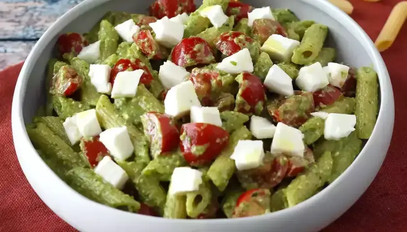 Penne z zielonym pesto, pomidorkami koktajlowymi i kostkami mozzarelli. Idealna sałatka z rukolą na letni obiad.