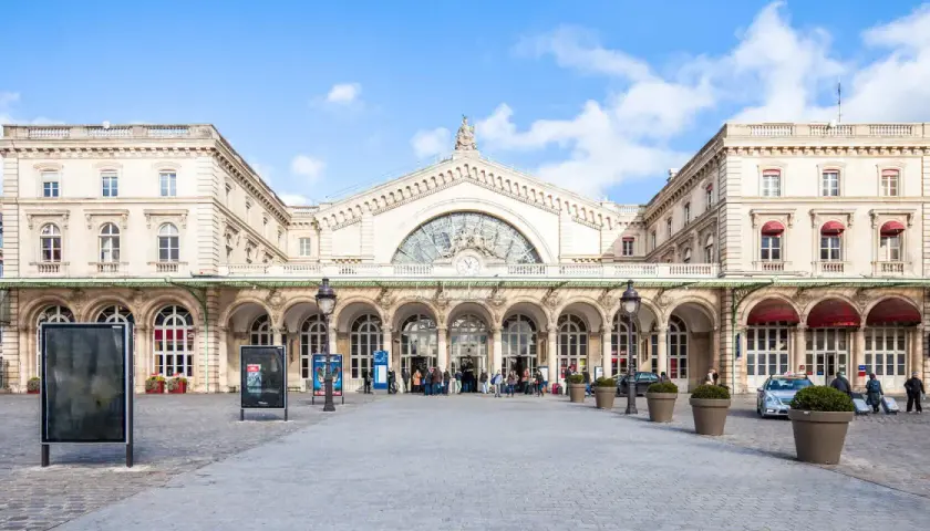 Prachtvoller Bahnhof in Paris Zentrum mit Bögen und einer großen Uhr.