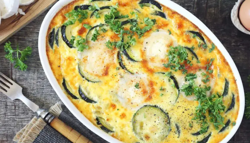 Clafoutis courgettes aux chèvres, garni de persil frais, prêt à être dégusté. Un délice simple et savoureux.