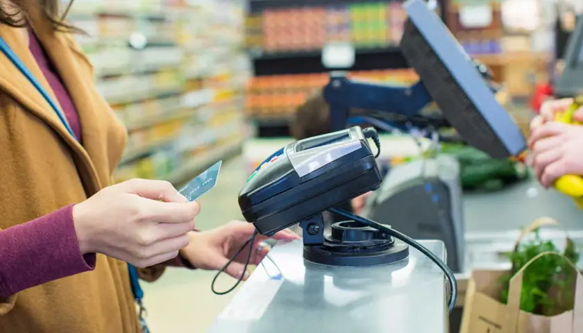 Une femme paie avec sa carte Visa. Si vous avez besoin de savoir comment annuler un paiement par carte Visa, contactez votre banque.