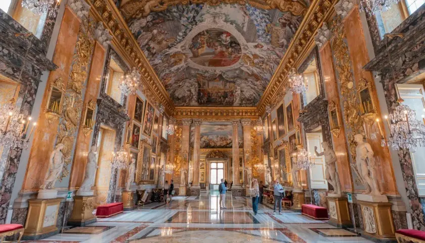 Intérieur somptueux du palais Colonna, avec fresques au plafond, statues, lustres en cristal et marbre au sol.