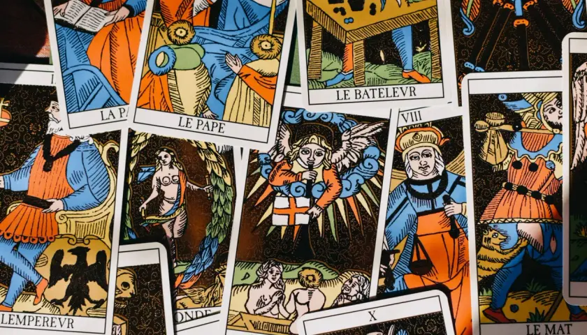 Rozłożone karty **tarot jedna karta** z kolorowymi ilustracjami postaci i symboli. Widoczne fragmenty kart "Le Pape", "Le Bateleur", "Le Mat".