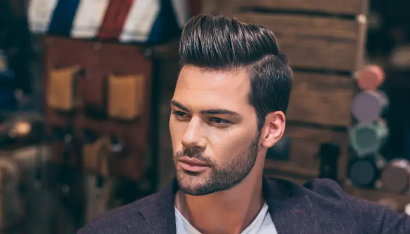 Hombre con peinado moderno y raya del pelo marcada a la derecha.