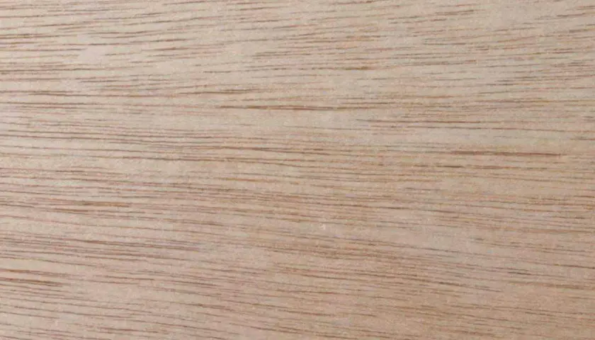 Superficie di legno okumè con venature sottili e parallele. Un legno duro, ideale per mobili e pavimenti.