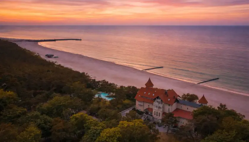 Zachód słońca nad Bałtykiem, malowniczy dworek i plaża. Idealne miejsce na wakacje w Polsce.
