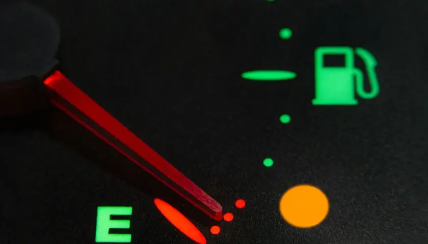 Indicador de combustible casi vacío, con la aguja roja apuntando a la 'E'. La luz de reserva está encendida. Así sabrás como saber si la llave del gas está abierta.