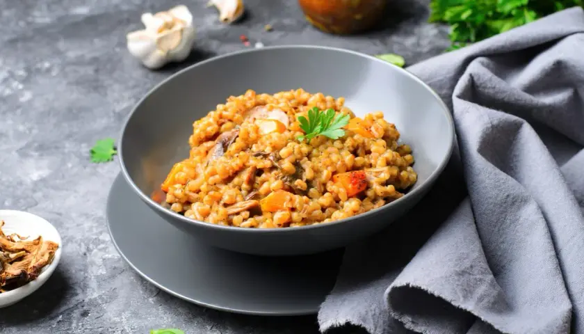Insalata di farro con funghi e verdure, guarnita con prezzemolo fresco. Un piatto gustoso e salutare.