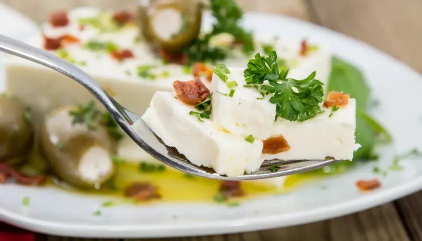 Ein Löffel mit selbstgemachtem Feta, Oliven und Kräutern. Frisch zubereitet und köstlich!
