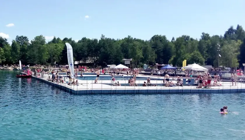 Ludzie odpoczywają i kąpią się na pomoście w Balatonie Trzebinia. Słoneczny dzień zachęca do relaksu nad wodą.
