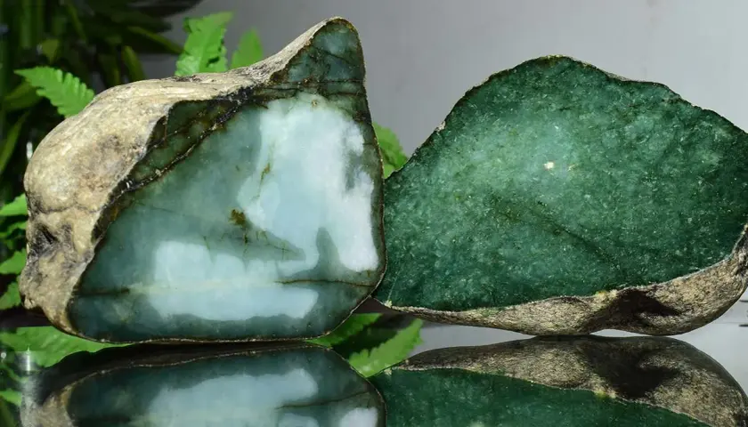 Zwei rohe Jade-Stücke, eines hellblau-grün, das andere tiefgrün. Die Jade-Name-Bedeutung spiegelt sich in ihrer Schönheit wider.