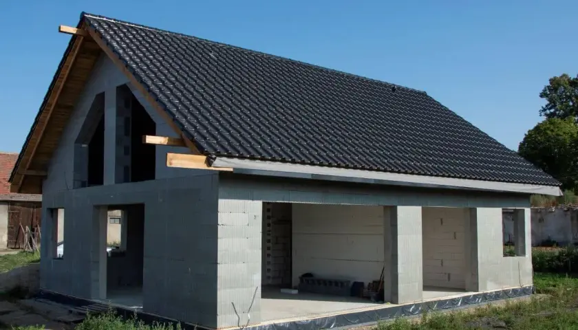 Budynek w budowie, z szarym dachem i betonowymi ścianami. To jeden z projektów budynków usługowych, który wkrótce zyska nowe życie.