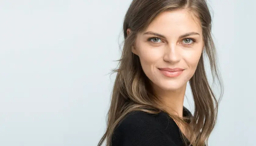 Mujer con un elegante corte de pelo media melena, mirada serena y una sonrisa sutil.
