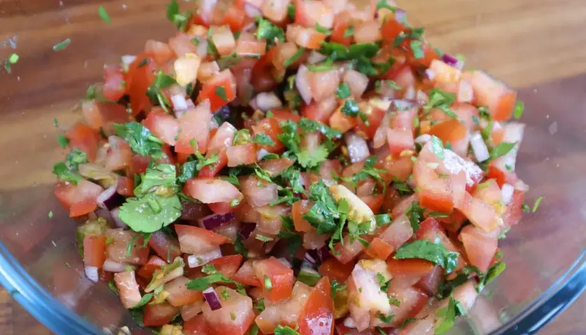 Świeża, kolorowa salsa pomidorowa z cebulą i kolendrą, gotowa do podania.
