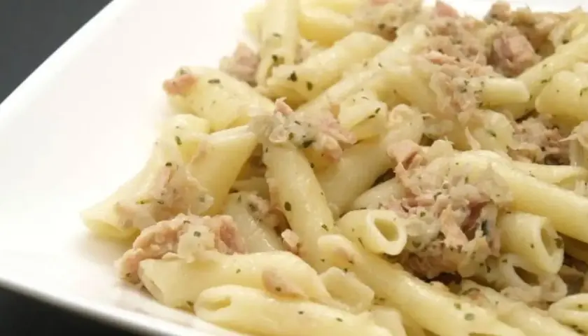 Macarrones con atún, un plato sencillo y delicioso. Pasta penne mezclada con atún desmenuzado y hierbas verdes.