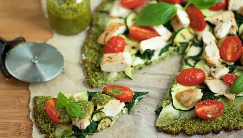 Pyszna pizza na spodzie z brokuła z kurczakiem, cukinią, pomidorkami i pesto.
