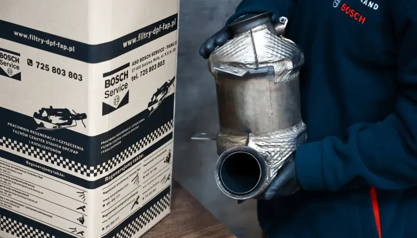 Osoba w rękawiczkach trzyma filtr DPF/FAP obok kartonu z logo Bosch Service.