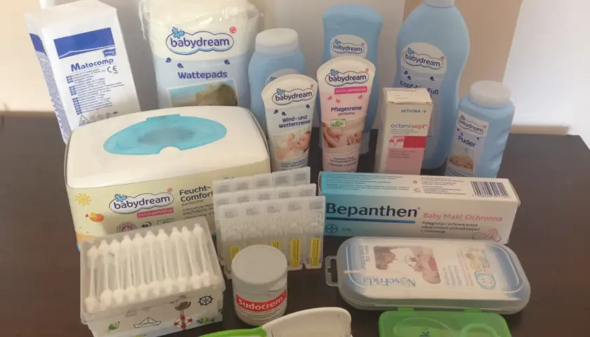 Zestaw kosmetyków dla noworodka: chusteczki, kremy, puder, płatki kosmetyczne, aspirator, grzebyk, nożyczki.
