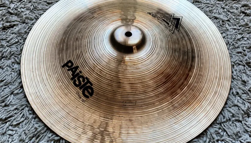 Paiste China 16" - ciche talerze perkusyjne, gotowe do tworzenia unikalnych brzmień na tle szarego dywanu.