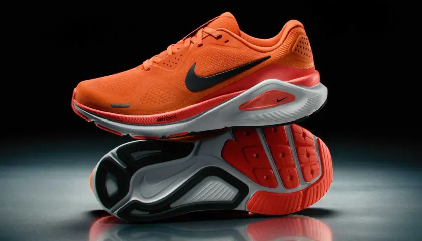 Pomarańczowe obuwie sportowe męskie Nike z czarnym logo. Idealne do biegania, zapewniające komfort i dynamikę.