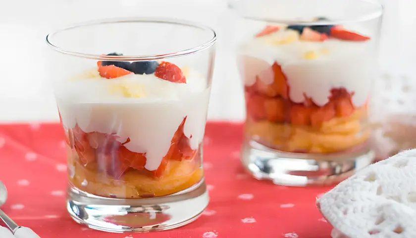 Delicioso tiramisú de fresa en capas, con bizcocho, fresas, crema y arándanos.