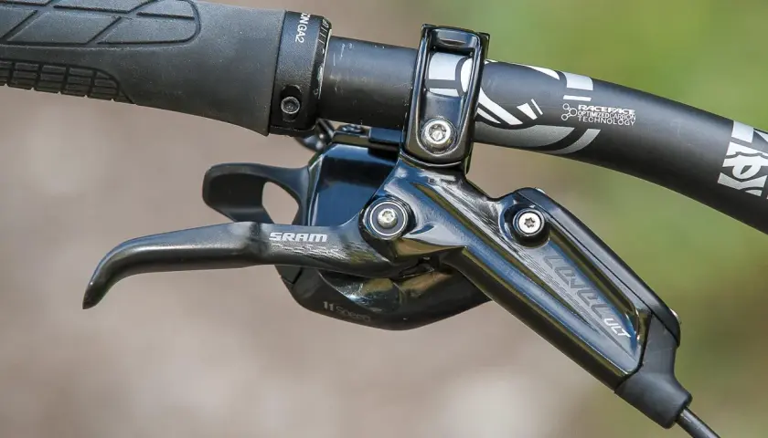 Close-up of a SRAM Level Ultimate brake lever on a mountain bike handlebar, ready for any trail.