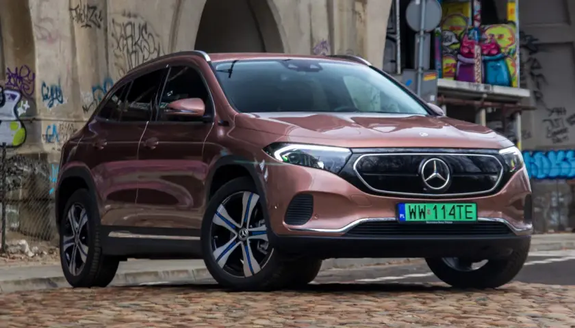 Różowy Mercedes EQA na tle graffiti.