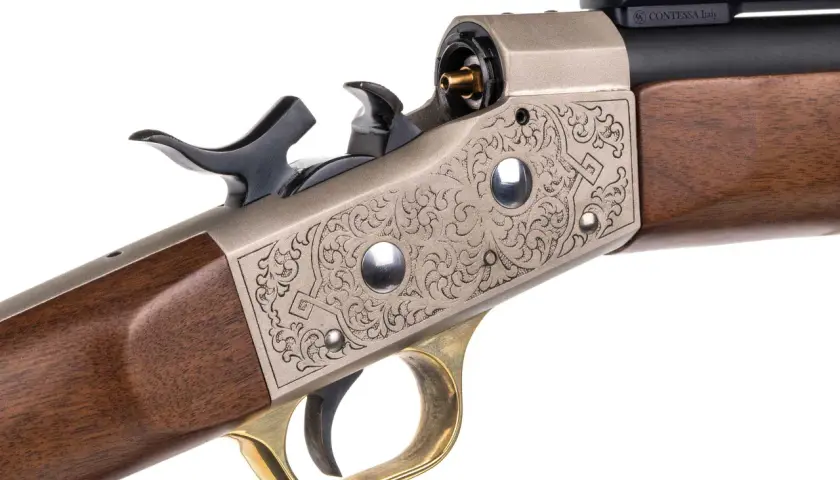 Elegancki karabin z grawerowanym zamkiem typu rolling block 50, drewnianą kolbą i mosiężnym językiem spustowym.