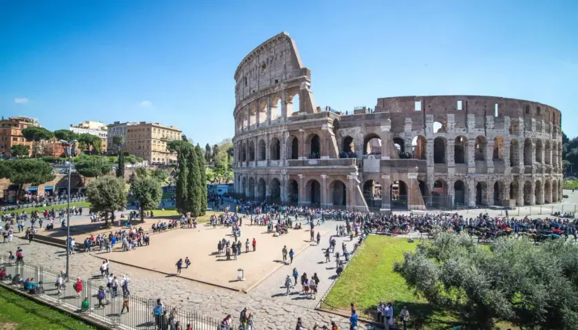 Le Colisée d'Italie, monument emblématique, accueille une foule de visiteurs sous un ciel bleu éclatant.