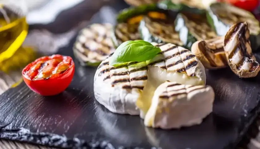 Pyszny camembert z grilla, z rumianymi paskami, podany z grillowanymi warzywami i pomidorkiem. Idealna przekąska na lato.
