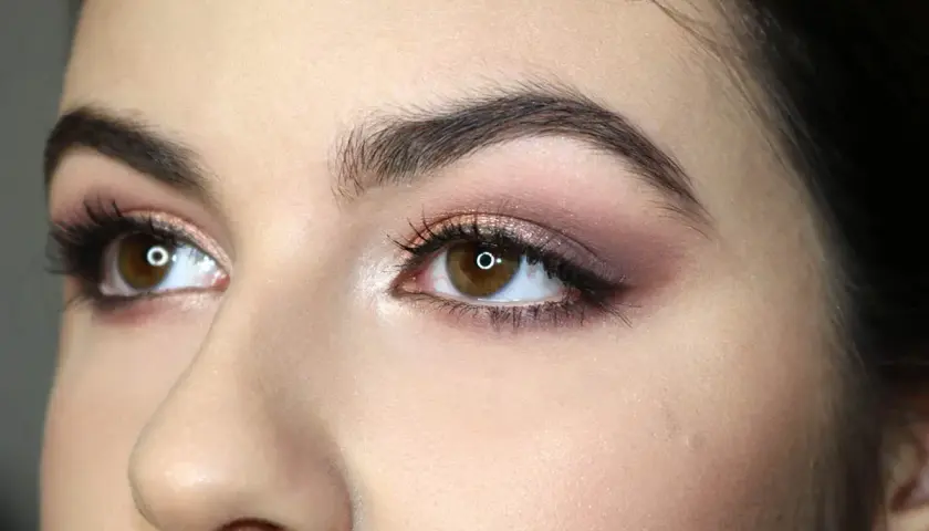 Occhi marroni con makeup sfumato sui toni del rosa e del bronzo, che ne esaltano la forma. Ciglia lunghe e folte.